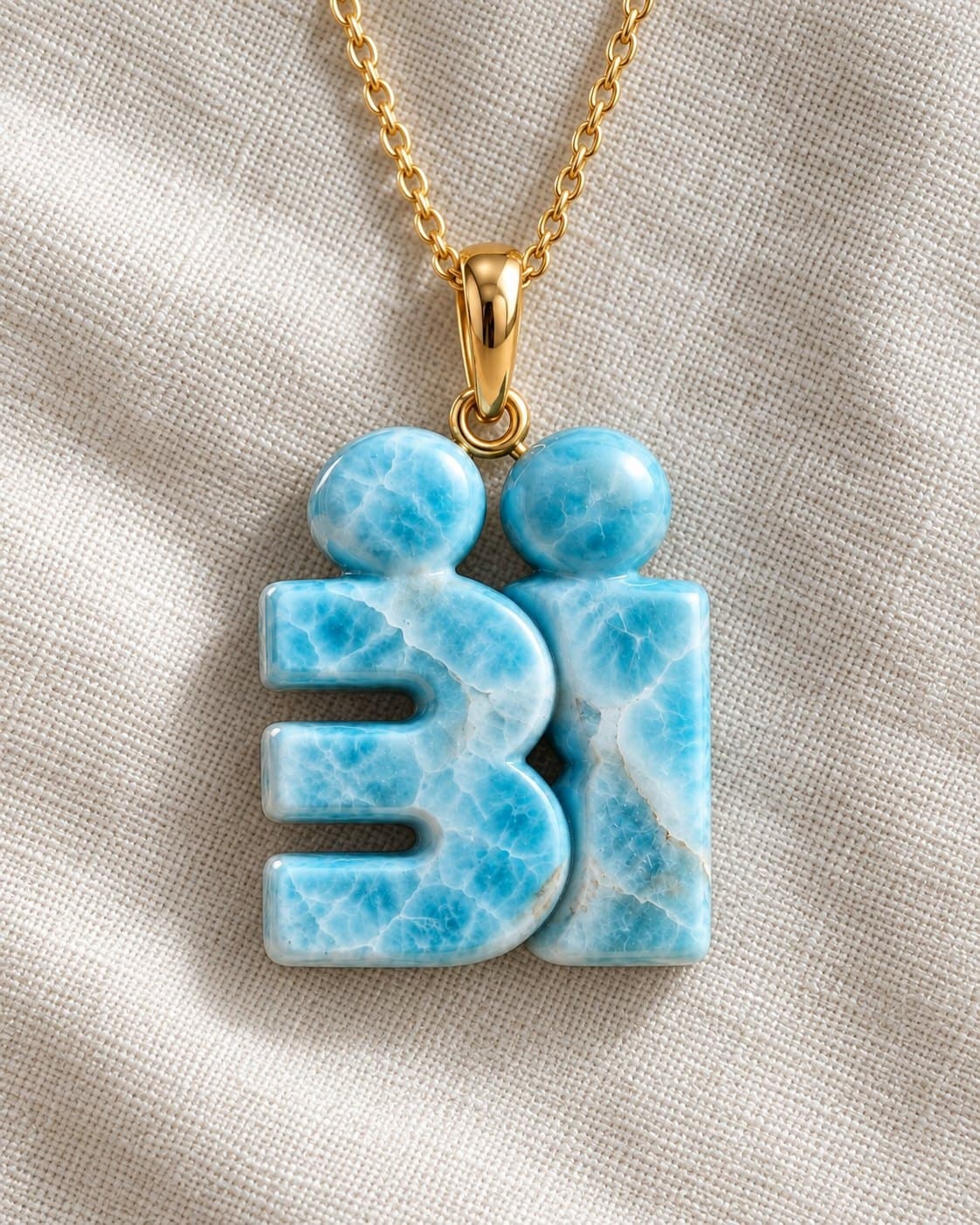 The “Bi” logo carved in natural larimar, on a golden chain