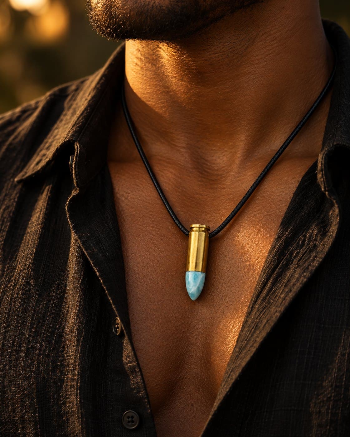 A man wearing the 9 mm Bullet necklace with a larimar tip